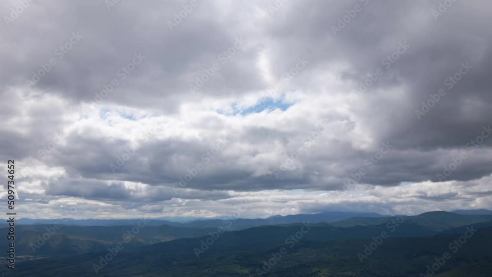 Aerial view from high altitude of distant mountain hills covered with puffy cumulus clouds forming before rainstorm. Airplane point of view of cloudy landscape Aerial view from high altitude of distant mountain hills covered with puffy cumulus clouds forming before rainstorm. Airplane point of view of cloudy landscape
