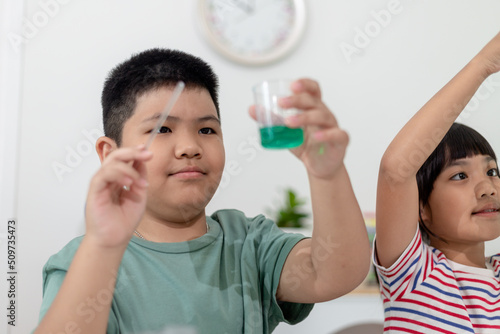 Asian Children enthusiastically watch chemistry experiments.