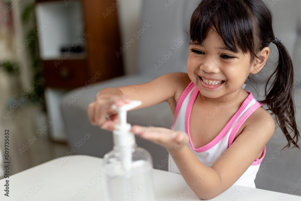 Little Asian girl child put alcohol gel sanitizer pump on Hands for cleaning or wash his hands. Little Asian girl child put alcohol gel sanitizer pump on Hands for cleaning or wash his hands.