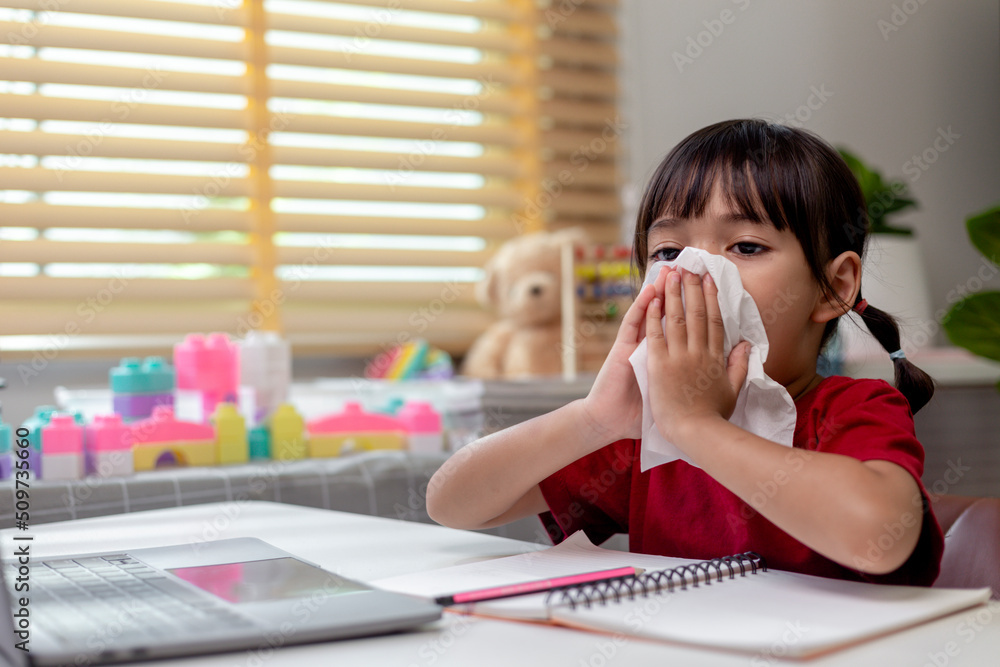 Unhealthy kid blowing nose into tissue, Child suffering from running nose or sneezing, A girl catches a cold when season change, childhood wiping nose with tissue Unhealthy kid blowing nose into tissue, Child suffering from running nose or sneezing, A girl catches a cold when season change, childhood wiping nose with tissue