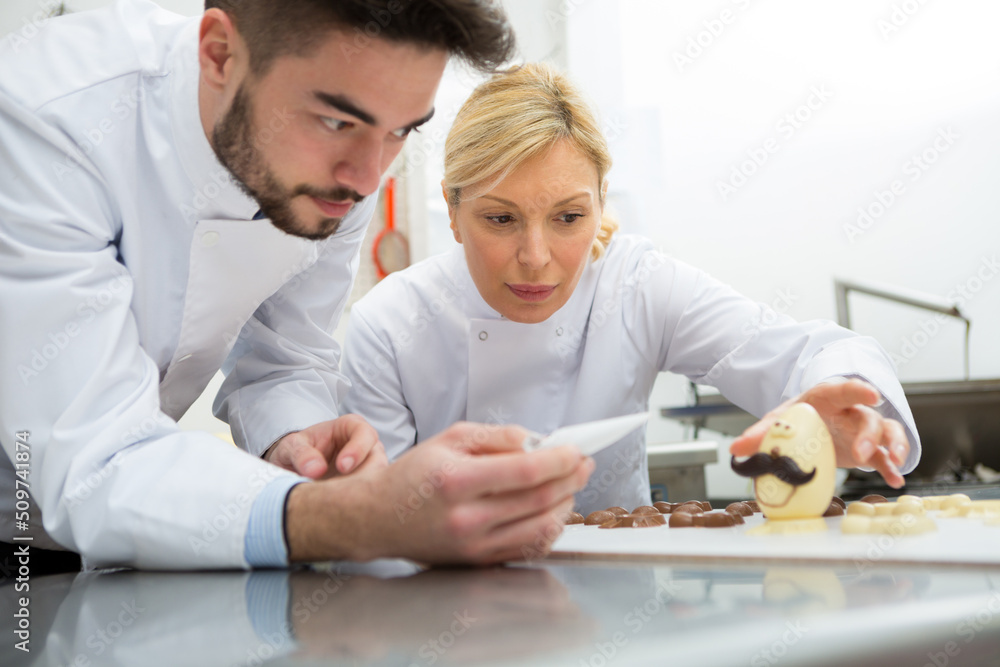 Obraz premium portrait of workers and chocolate eggs