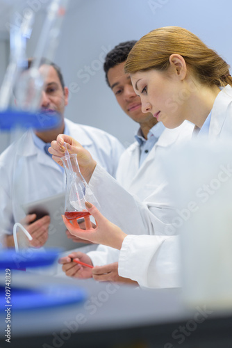young female scientist working with olleagues in lab photo