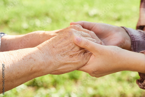 Fotografia hands of a young woman hold the hands of a grandmother close-up.