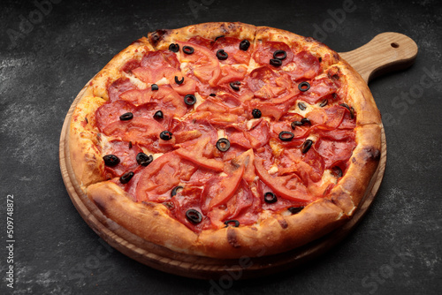 Pepperoni pizza on a round wooden board