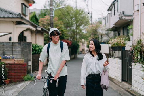 買い物から小さな住宅街を歩いて帰る母親と10代の息子