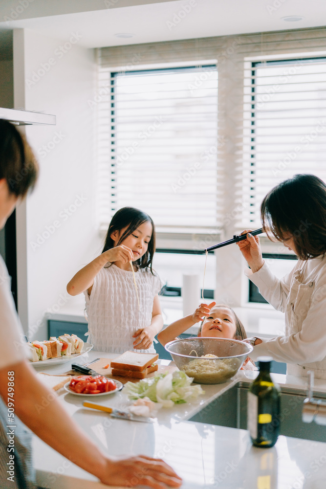 パスタを味見する姉妹と見守る父と祖母 パスタを味見する姉妹と見守る父と祖母