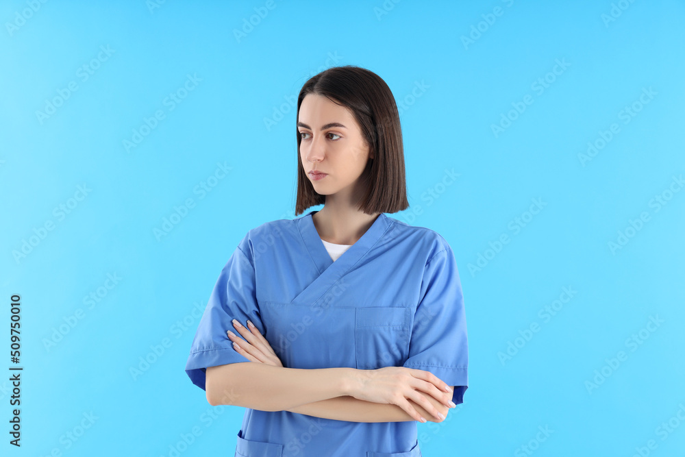 Attractive young female doctor on blue background Attractive young female doctor on blue background