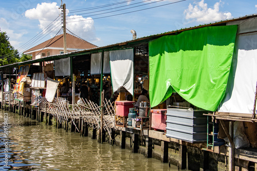 Water canal with shops and restaurants at Khlong Lat Mayom Floating Market, Bangkok, Thailand. photo