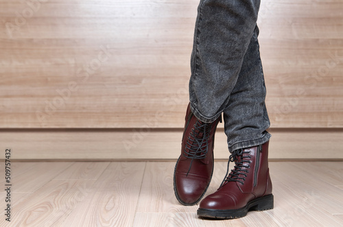 Closeup of woman legs in red leather boots and black jeans