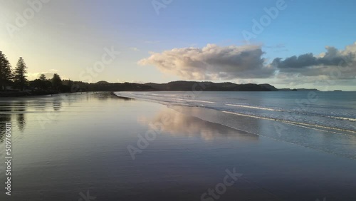 Wallpaper Mural Sunset reflections cinematically flying drone sideways over waves at low tide in New Zealand Torontodigital.ca