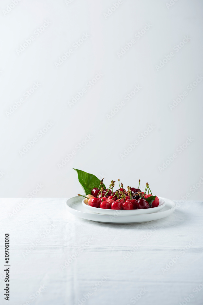 Sweet cherrys on the white linen tablecloth Sweet cherrys on the white linen tablecloth