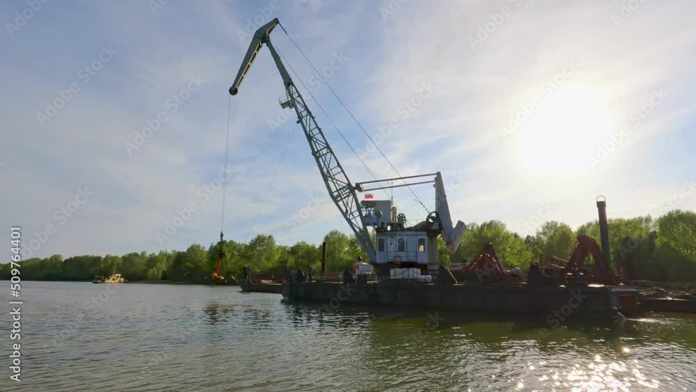 Large digger on a barge dredging and deepening the river for ships to pass.
Cleaning and deepening the river for navigation. Dredging boat is working to deepen the fairway on the river