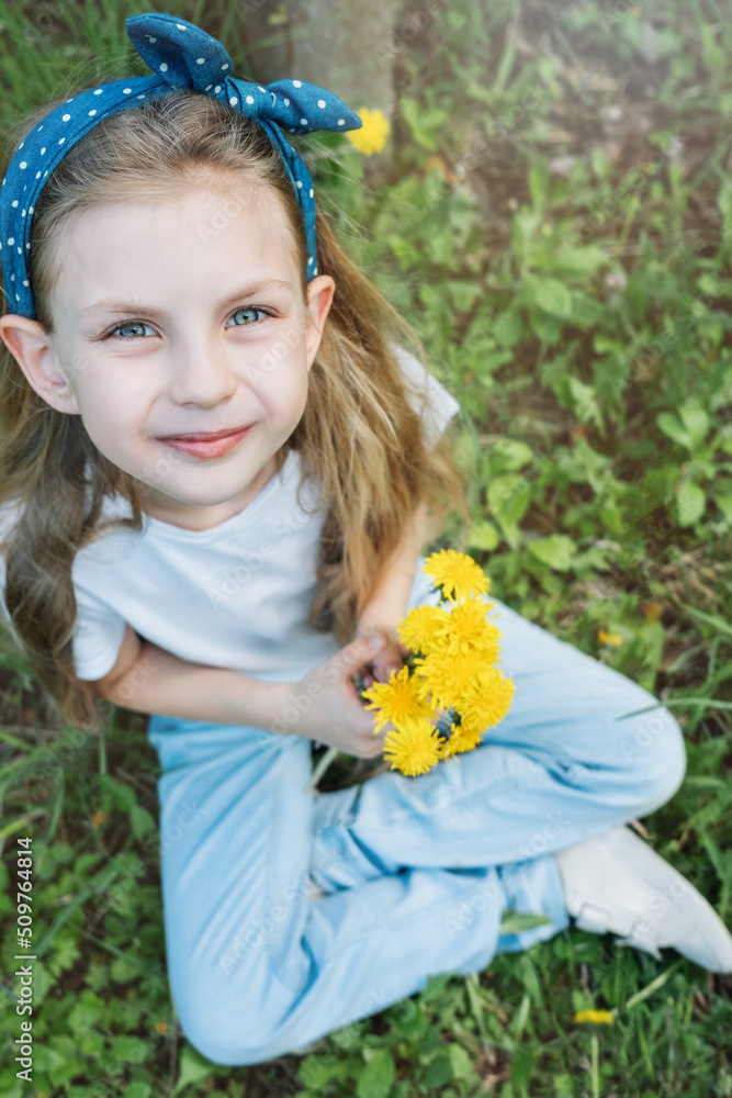 Image of pretty little girl sitting on dandelions field Image of pretty little girl sitting on dandelions field