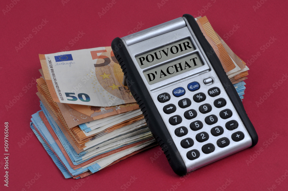 Concept de pouvoir d'achat avec une calculatrice posée sur des billets de banque en euros sur fond rouge Concept de pouvoir d'achat avec une calculatrice posée sur des billets de banque en euros sur fond rouge