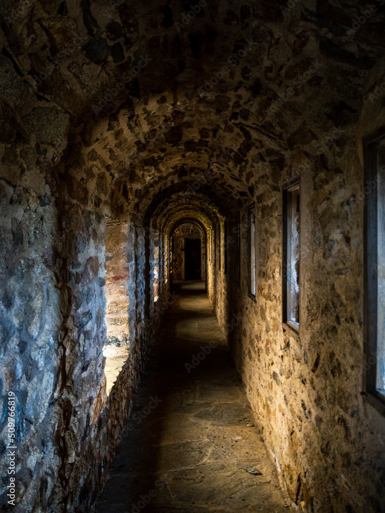 Obraz premium imagen de un pasillo de un Castillo de piedra con la luz que entra por las ventanas 