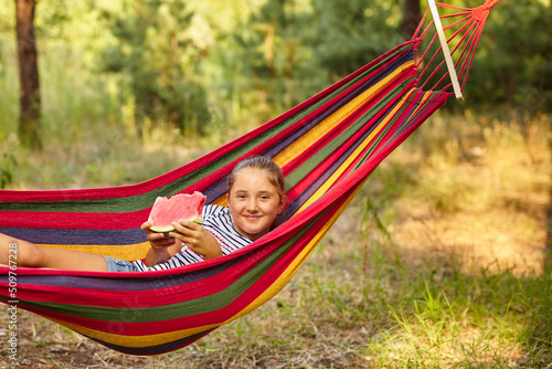 Cute little girl resting in a colored hammock i