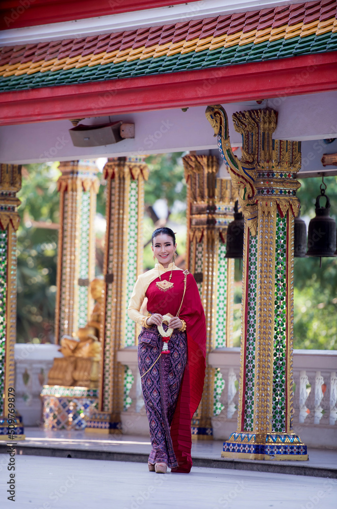 Obraz premium Portrait of young Asian women in traditional Thai costumes worshiping Buddha images with flower garlands. Preserving the good culture of Thai people during Songkran Festival, Thai New Year, April Fami
