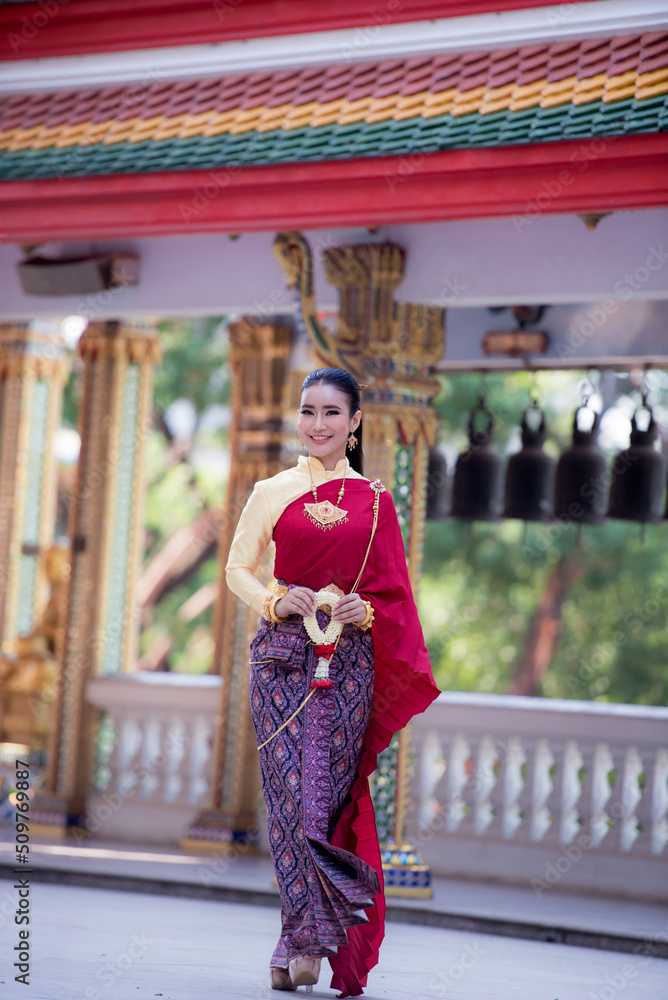 Portrait of young Asian women in traditional Thai costumes worshiping Buddha images with flower garlands. Preserving the good culture of Thai people during Songkran Festival, Thai New Year, April Fami