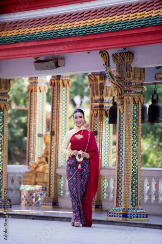 Portrait of young Asian women in traditional Thai costumes worshiping Buddha images with flower garlands. Preserving the good culture of Thai people during Songkran Festival, Thai New Year, April Fami