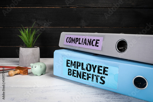  EMPLOYEE BENEFITS and COMPLIANCE. Document binders, folders on a wooden office desk