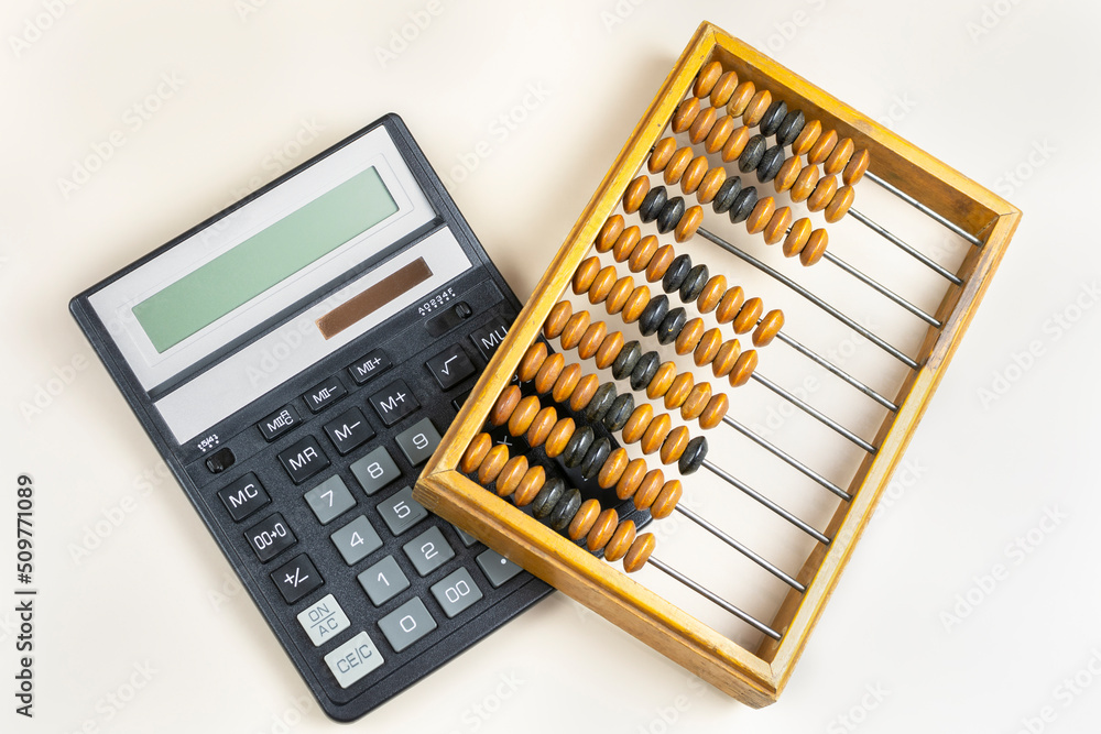 Old antique wooden abacus and modern calculator on a gray background. Old antique wooden abacus and modern calculator on a gray background.