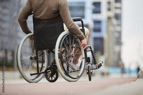 Fotografie Unrecognizable disabled man in casual clothing using assistive device for person