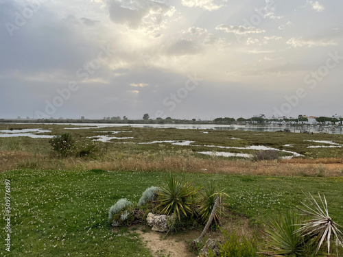 View of the beach of Isla Canela, Huelva, with boats and town in the background. photo