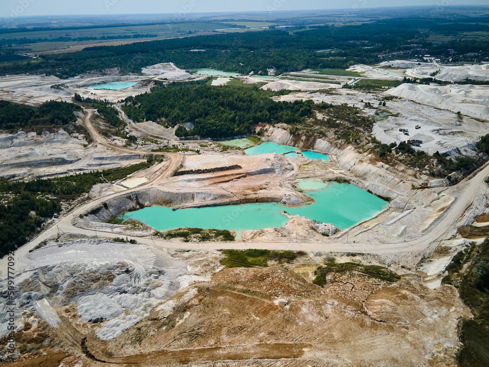 Aerial view quarry extraction porcelain clay, kaolin, with turquoise water and white shore, drone view open pit mine kaolin flooded with water