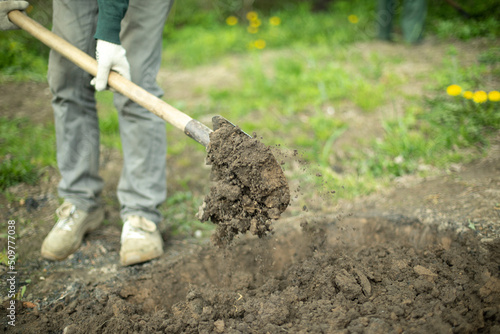 Guy is digging ground. Man with shovel. Details of rural life.