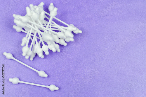 Cotton swabs with a limiter on a purple (lilac) background. Cleaning the baby's ears. Space for the text. Child care and hygiene.