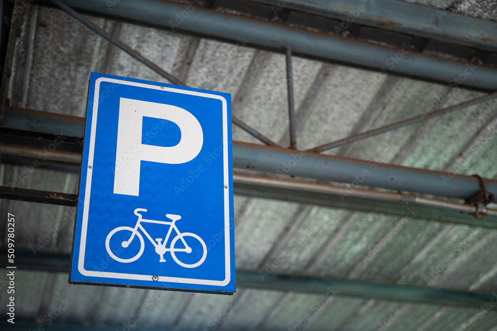 Bicycle parking lot reservation sign which is installed on the parking ceiling structure. Transportation and traffic symbol object photo. Bicycle parking lot reservation sign which is installed on the parking ceiling structure. Transportation and traffic symbol object photo.