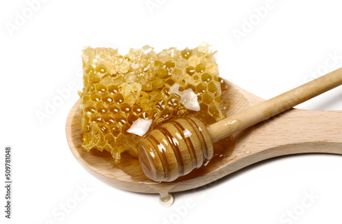 Honey and honeycomb in wooden spoon and wooden dipper isolated on white  