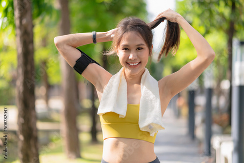 sport asian female teen portrait shot while morning running jogging healthy routine activity sunnday at public park,asia woman wear sport wear smile look at camera while take a break from run exercise photo