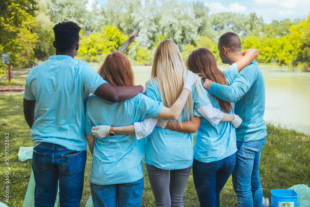 A diverse group of young adults volunteer together. They are embraced and satisfied with their work. The concept of community, friendship and volunteering A diverse group of young adults volunteer together. They are embraced and satisfied with their work. The concept of community, friendship and volunteering