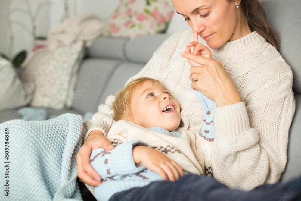 Mother and child, blond boy, lying on the couch at home Mother and child, blond boy, lying on the couch at home