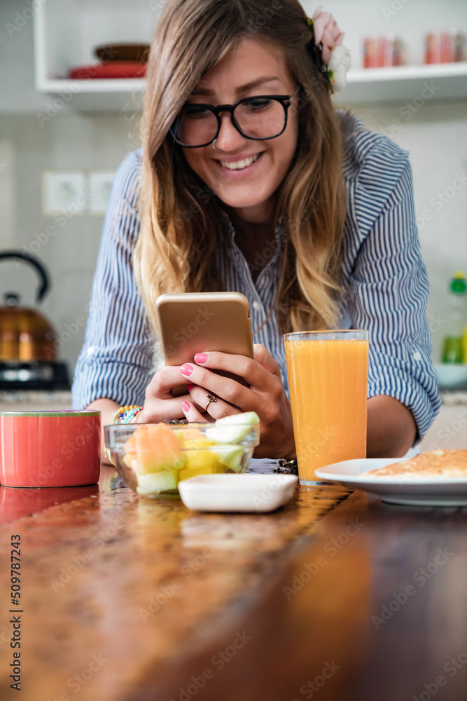 Young adult woman using smartphone in a modern home. Young adult woman using smartphone in a modern home.
