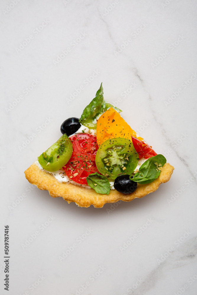 Overhead view of one piece tomato cheese quiche Overhead view of one piece tomato cheese quiche