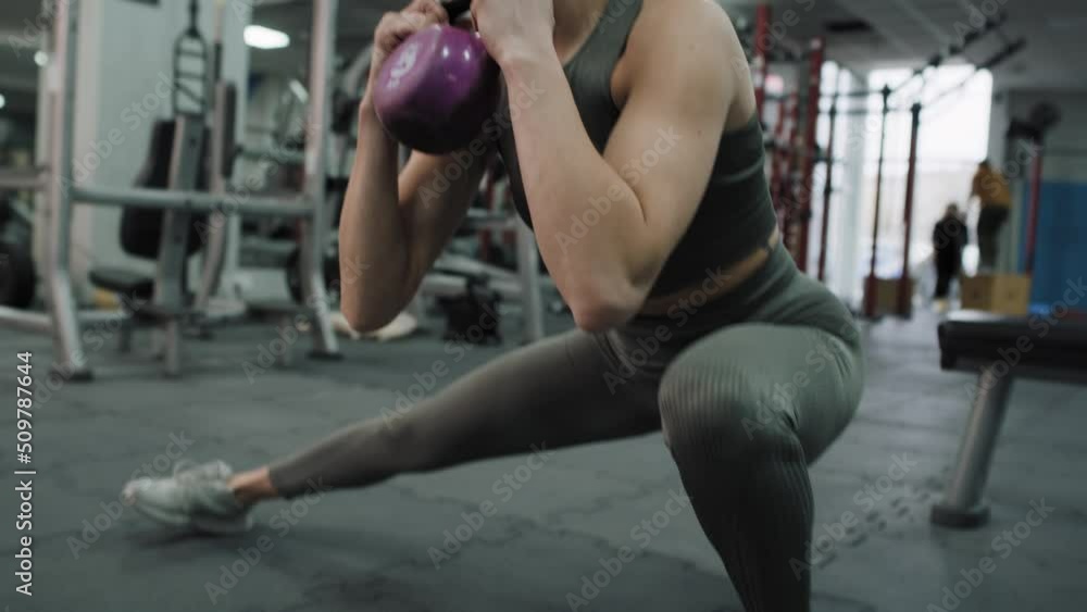Young caucasian woman exercising with kettlebells at a gym. Shot with RED helium camera in 8K. Young caucasian woman exercising with kettlebells at a gym. Shot with RED helium camera in 8K.