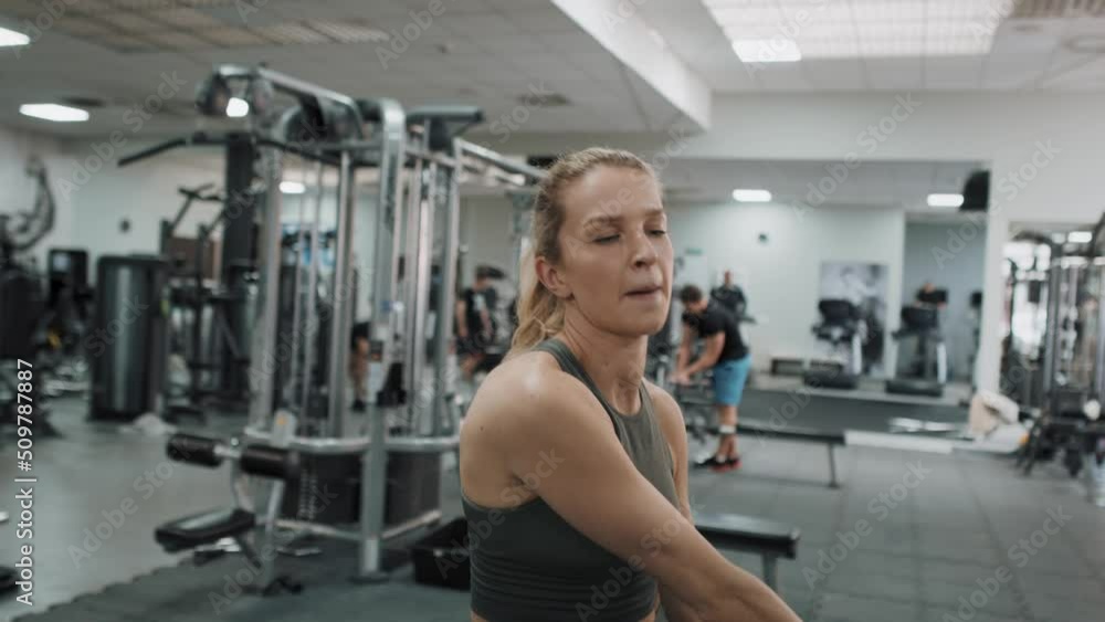 Focus caucasian woman exercising with barbell in the gym. Shot with RED helium camera in 8K. Focus caucasian woman exercising with barbell in the gym. Shot with RED helium camera in 8K.