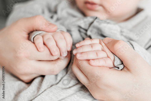 Mom holds the hands of a newborn baby. Emotional connection with the baby. Ukrainian newborn. Baby in mother's arms
