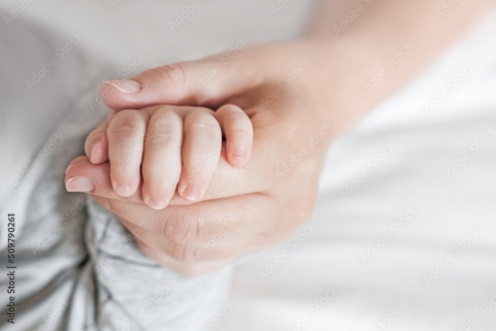 Hand of sleeping baby in the hand of mother. Newborn baby with mom. Motherhood care and baby care Hand of sleeping baby in the hand of mother. Newborn baby with mom. Motherhood care and baby care