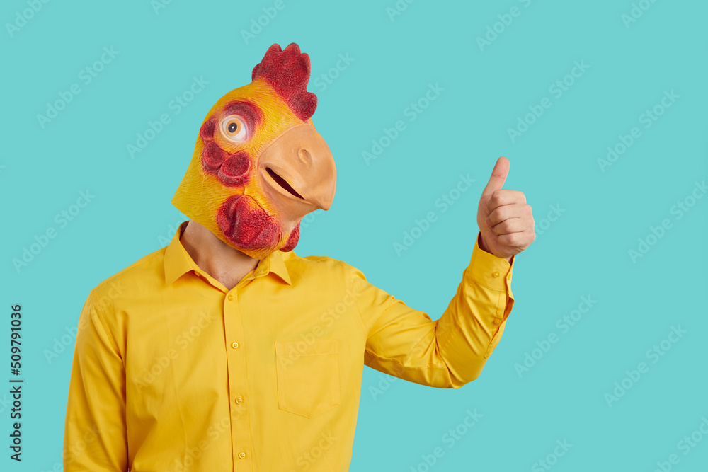 Funny man with chicken head raises his thumb up demonstrates you OK