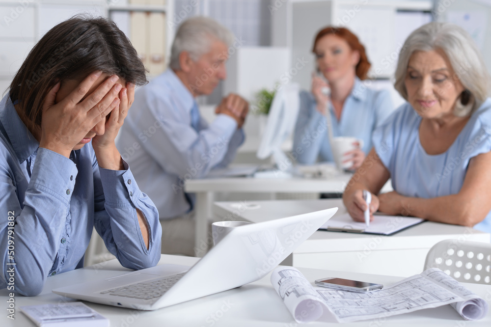 Tired businesspeople working in modern light office Tired businesspeople working in modern light office