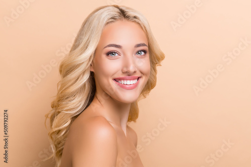 Profile side view portrait of attractive cheerful wavy-haired woman shine suntan copy space isolated over beige pastel color background