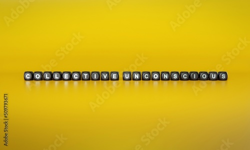 Words ‘Collective unconscious’ spelled out in white text on dark wooden blocks against plain yellow background. 3D rendering © HTGanzo
