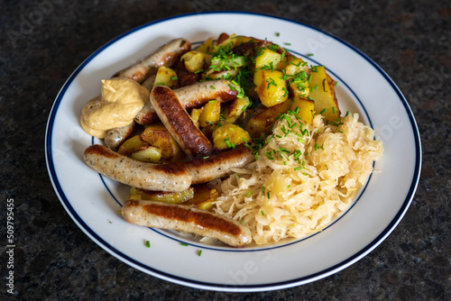 ready to eat, bratwurst and sauerkraut with fried potatoes and sauce