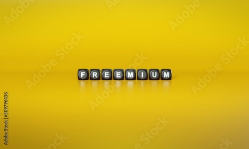 Word ‘Freemium’ spelled out in white text on dark wooden blocks against plain yellow background. 3D rendering photo