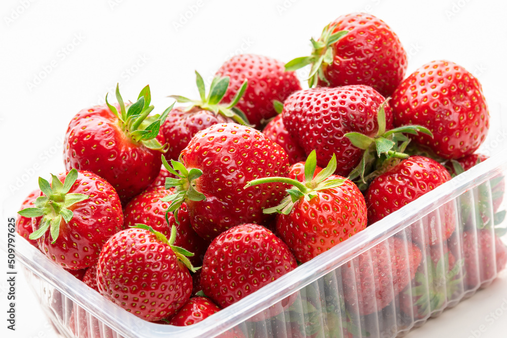 Ripe strawberries in a plastic box. Isolate on white background Ripe strawberries in a plastic box. Isolate on white background