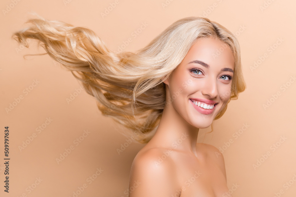 Profile side photo of amazing smiling lady with long flying hair advertising haircare product isolated on beige color background Profile side photo of amazing smiling lady with long flying hair advertising haircare product isolated on beige color background
