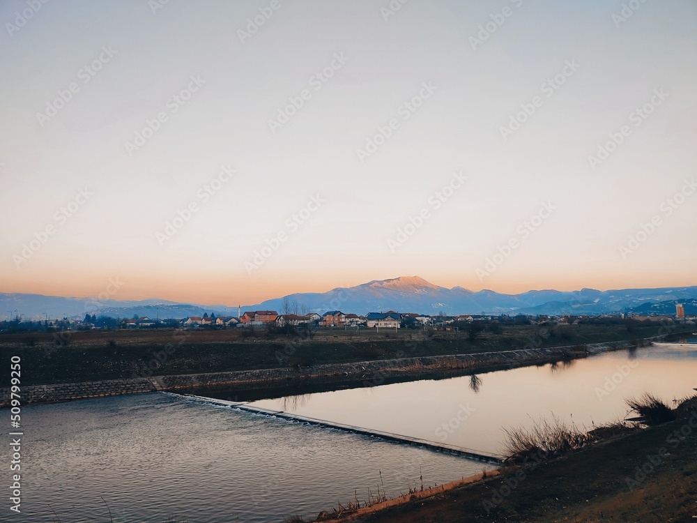 sunset over the river in spring with beautiful mountain backdrop